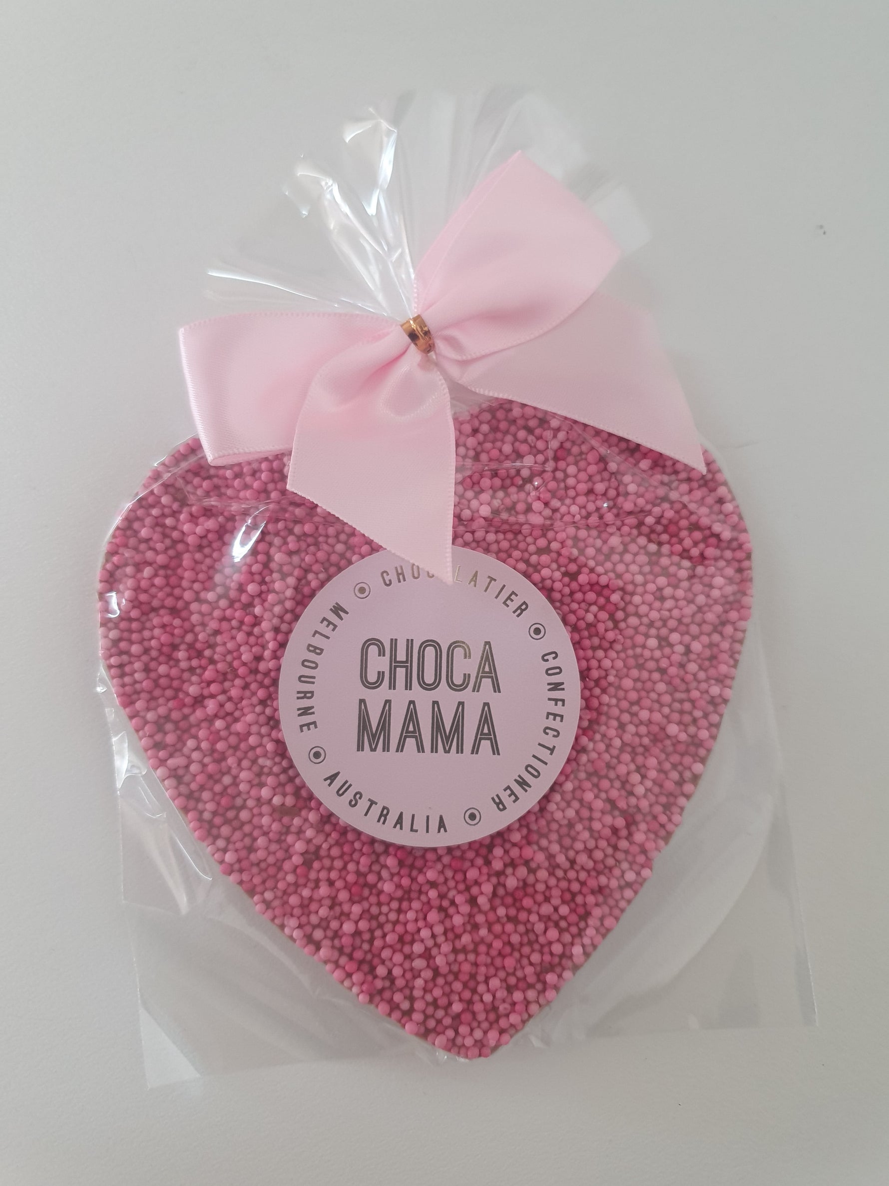 Pink confectionery sprinkles heart with a pink bow and 'Choco Mama' label on a white background
